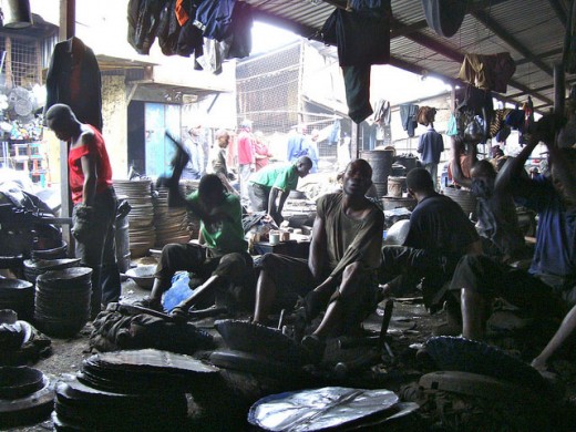 Jua Kali artisans busy at work making buckets and pans out of metal