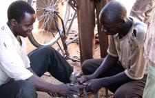 Youth unemployment may be due to a lack of capital for entrepreneurship. A Ugandan youth working on a bicycle