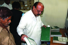 A tax collector reviews documentation from a citizen in Punjab, Pakistan A tax collector reviews documentation from a citizen in Punjab, Pakistan