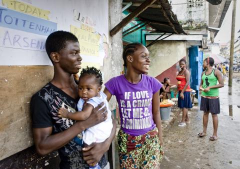 Men, women, and children stand on a street in Liberia. © 2010 Glenna Gordon