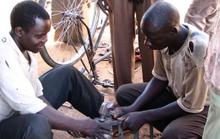 Youth unemployment may be due to a lack of capital for entrepreneurship. A Ugandan youth working on a bicycle