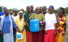 A group of people hold a chlorine dispenser A group of people hold a chlorine dispenser